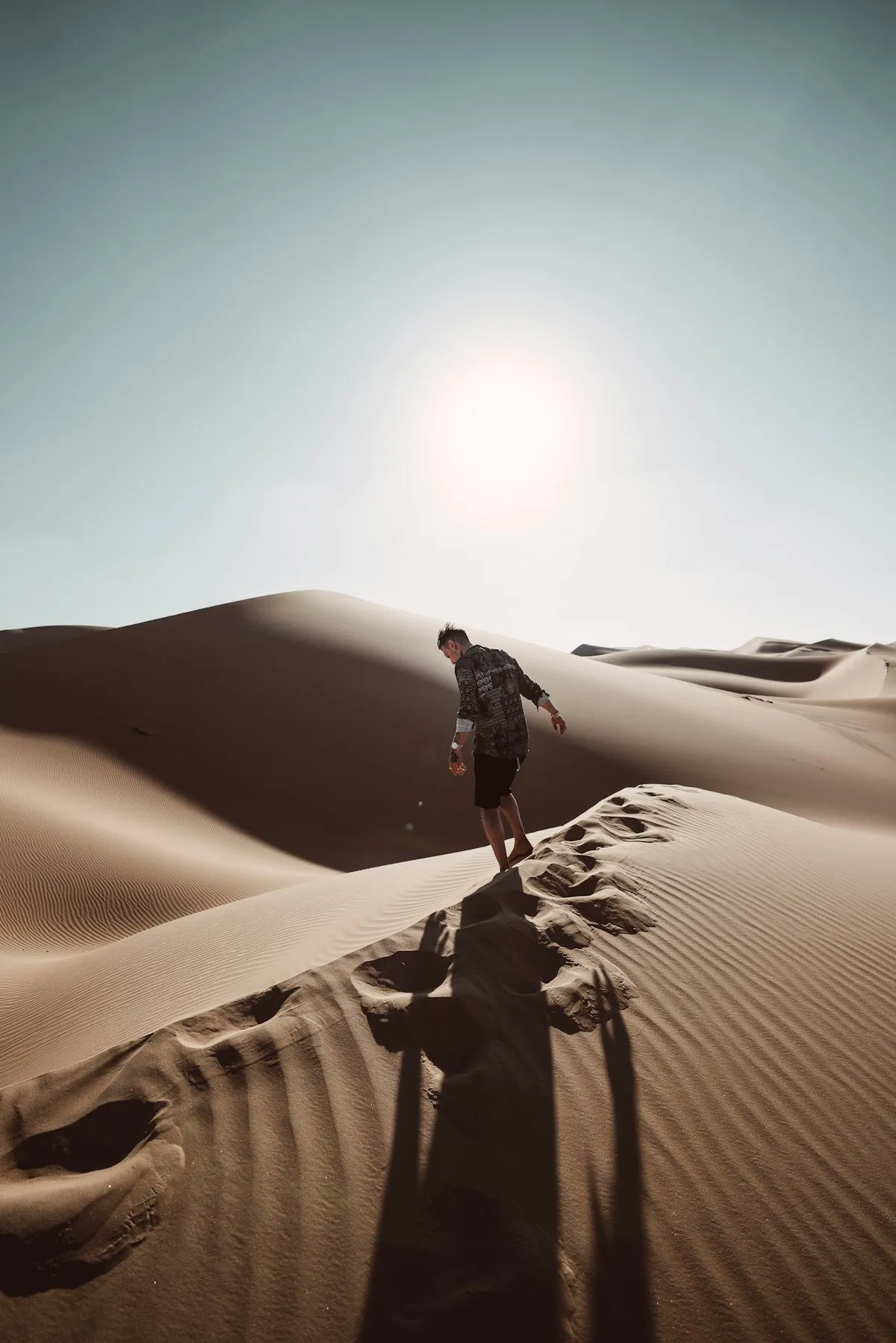 Traveller walking across golden desert dunes near Abu Dhabi