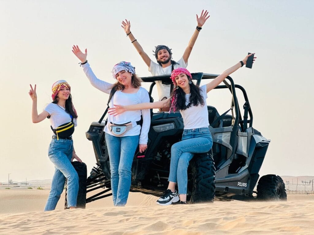 Family riding 4 seater dune buggy in Abu Dhabi desert dunes