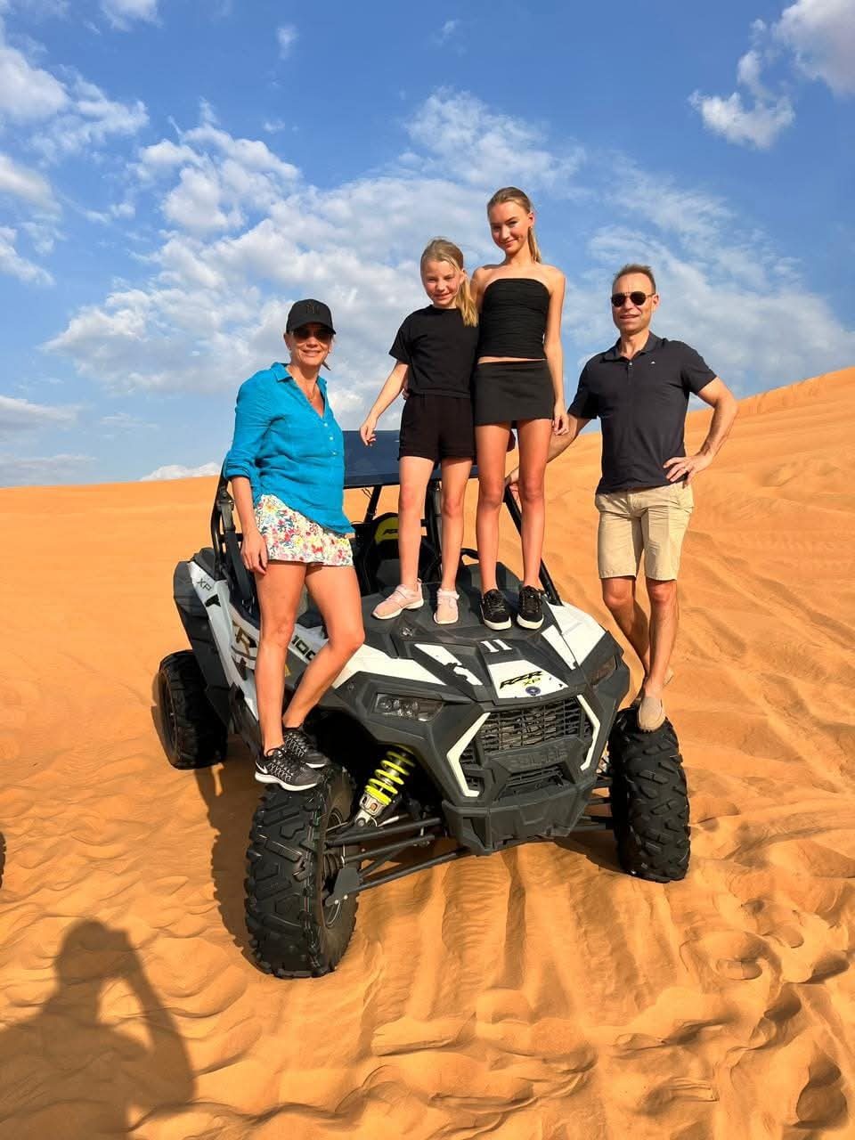 Couple riding 2 seater dune buggy in Abu Dhabi desert dunes