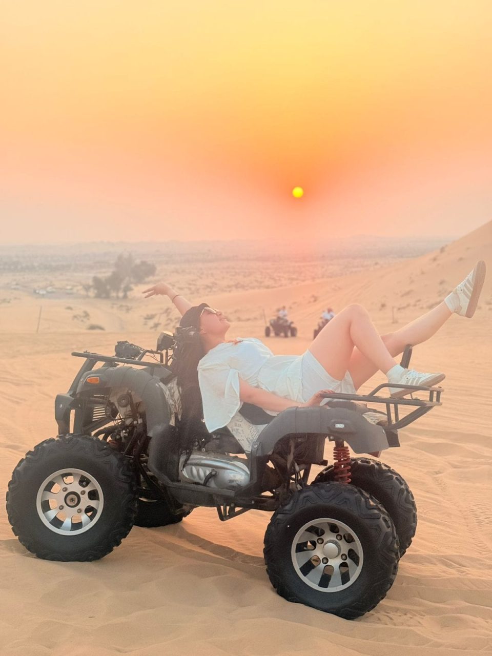 Tourist enjoying ATV quad biking during evening desert safari in Abu Dhabi