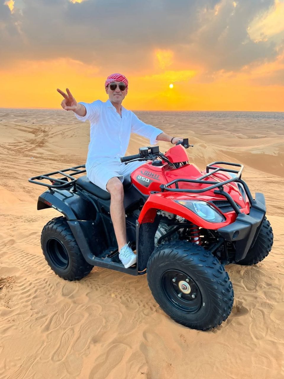 Tourists riding ATV quad bikes during morning desert safari in Abu Dhabi
